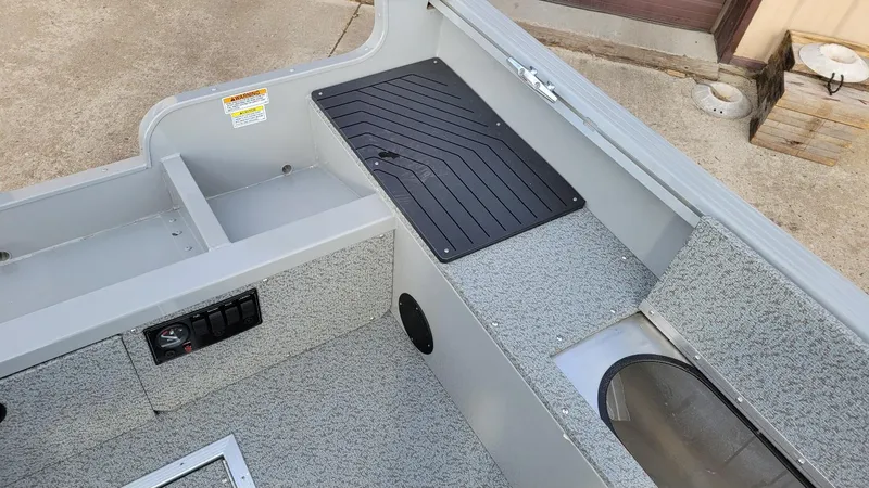 Slide: The Image of 2023 Smoker Craft Freedom 16 interior with Yamaha F25LWHC, featuring carpeted flooring and storage compartments. - 19