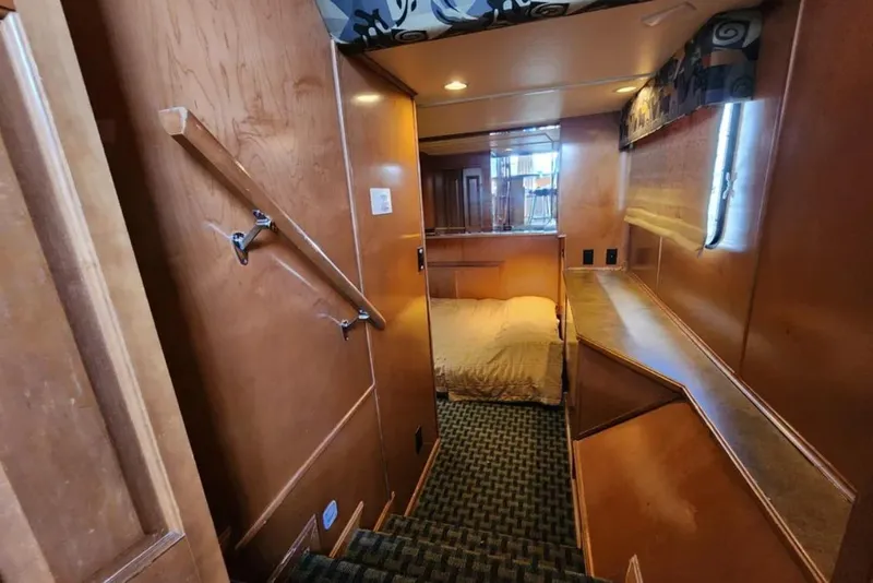 Slide: The Image of Interior of 2008 Sumerset Blue Moon Trip houseboat, featuring cozy bedroom and wooden decor. - 14