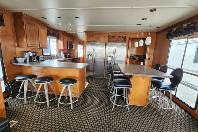 Slide: The Image of Luxurious Sumerset Blue Moon 2008 houseboat kitchen with bar stools, modern appliances, and elegant lighting. - 21