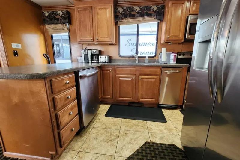 Slide: The Image of Kitchen interior of 2008 Sumerset Blue Moon Trip #11 houseboat, featuring wooden cabinets and stainless steel appliances. - 22