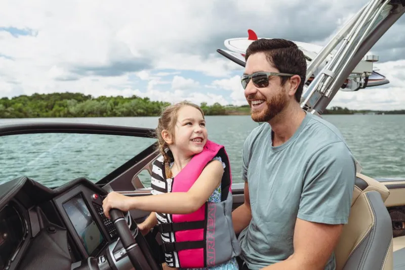 Slide: The Image of Father and daughter enjoying a ride on a 2023 MasterCraft XStar boat. - 11
