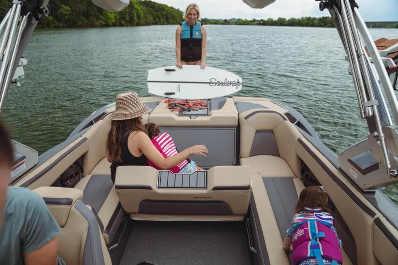 Slide: The Image of 2023 MasterCraft XStar boat with family enjoying water activities. - 14