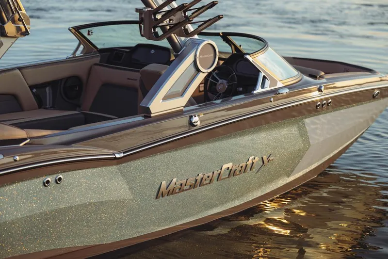 Slide: The Image of 2023 MasterCraft XStar boat on water, showcasing sleek design and luxurious interior. - 2