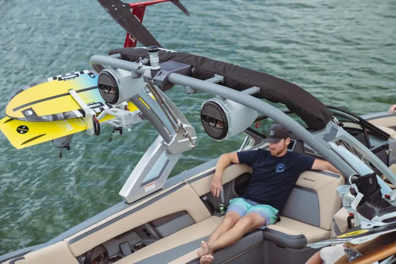 Slide: The Image of 2023 MasterCraft XStar boat with wakeboards and a relaxed passenger. - 8