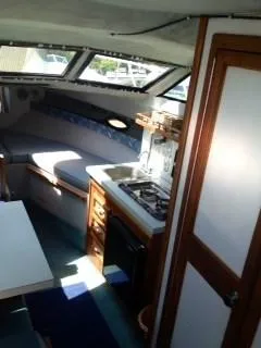 Slide: The Image of Interior of 1988 Baha Cruisers 260 Express Cruiser with kitchenette and seating area. - 2