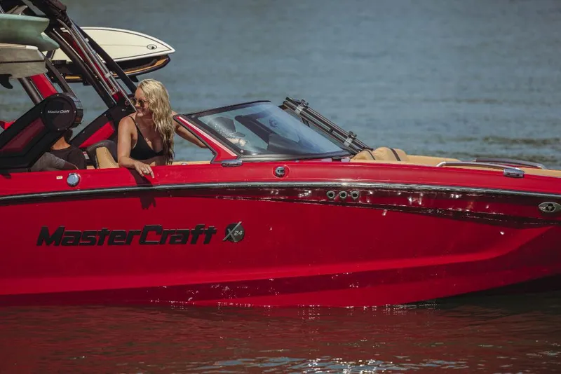 Slide: The Image of 2023 MasterCraft X24 boat on water with a woman onboard. - 1
