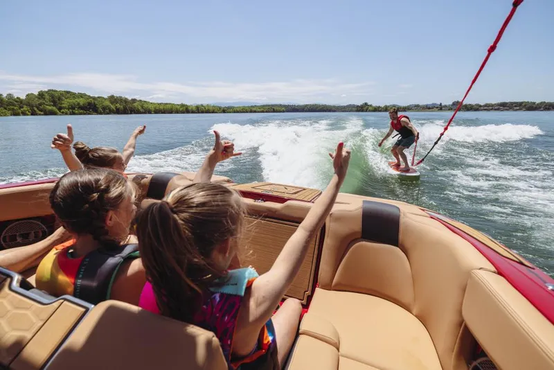 Slide: The Image of 2023 MasterCraft X24 boat towing a wakeboarder, with kids cheering onboard. - 12