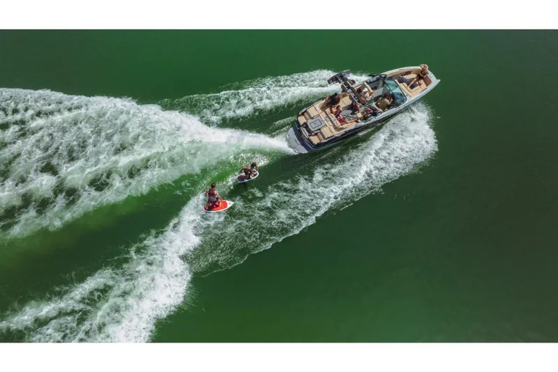 Slide: The Image of 2023 MasterCraft X26 boat towing two wakeboarders on a lake. - 13