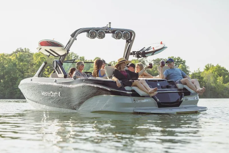Slide: The Image of 2023 MasterCraft X26 boat with people relaxing on the water. - 15