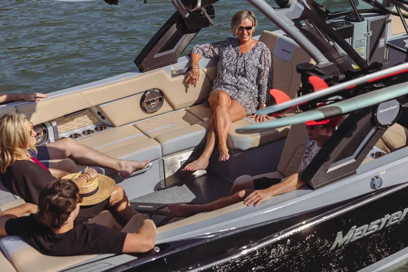 Slide: The Image of 2023 MasterCraft X26 boat with people relaxing on deck. - 2