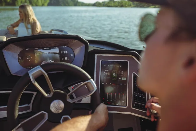 Slide: The Image of 2023 MasterCraft X26 boat dashboard with touchscreen controls on a lake. - 6