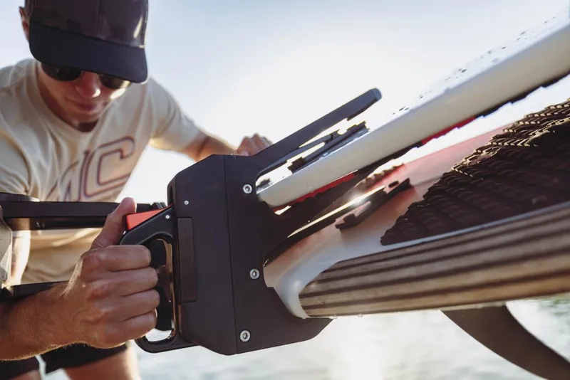 Slide: The Image of Man securing a wakeboard on a 2023 MasterCraft X26 boat. - 8