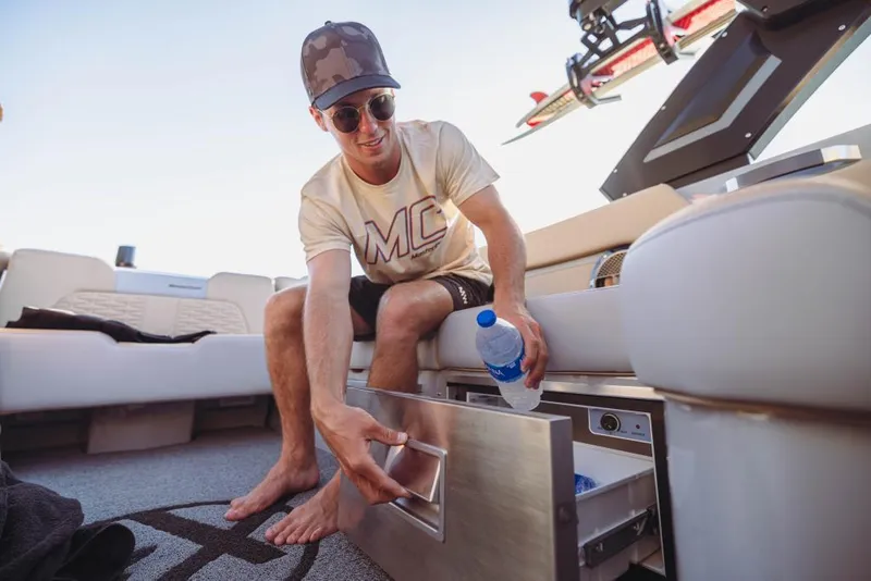 Slide: The Image of Man on 2023 MasterCraft X26 boat accessing storage drawer. - 9