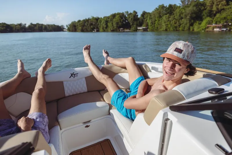 Slide: The Image of People relaxing on a 2023 MasterCraft XT20 boat on a sunny lake. - 11