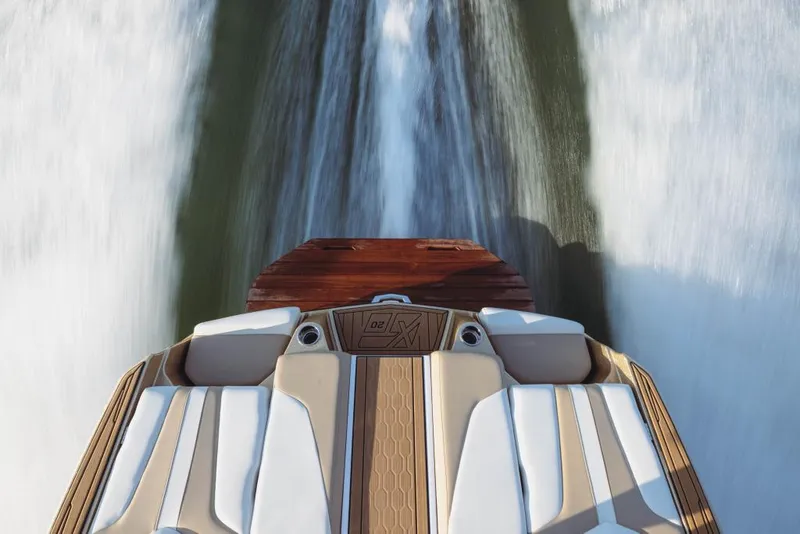 Slide: The Image of 2023 MasterCraft XT20 boat cruising on water, rear view. - 13