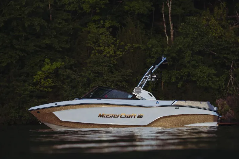 Slide: The Image of 2023 MasterCraft XT20 boat on calm water with forest background. - 16