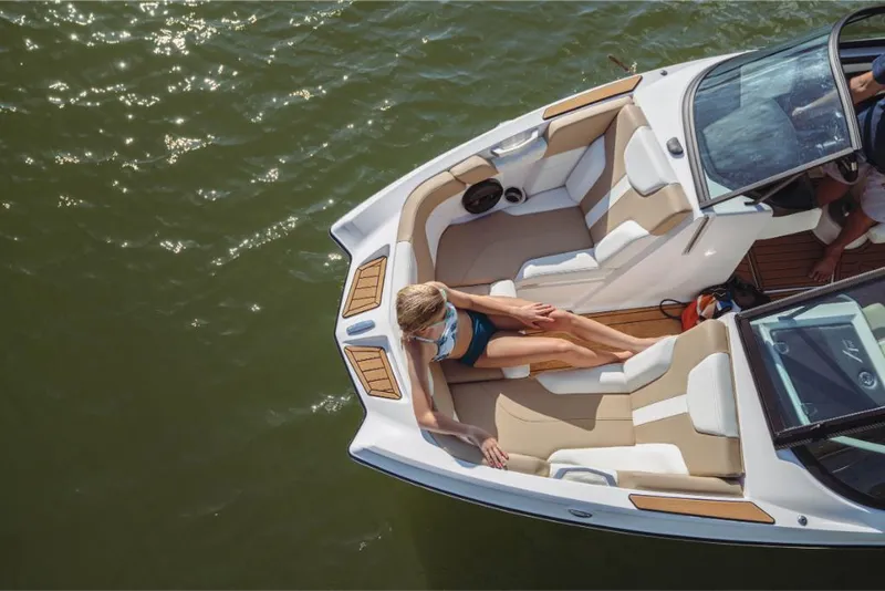 Slide: The Image of 2023 MasterCraft XT20 boat with a woman relaxing on the deck in the water. - 5