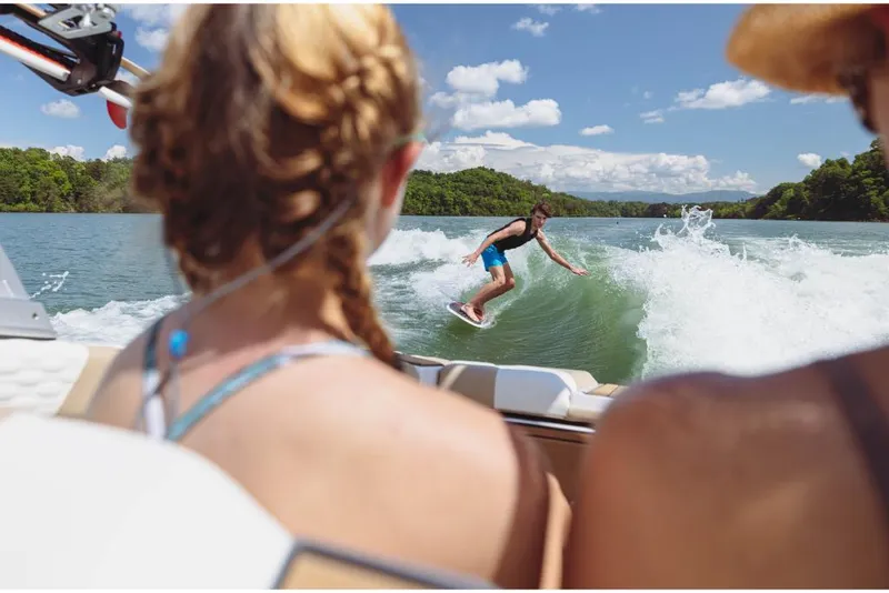 Slide: The Image of People enjoying wakeboarding behind a 2023 MasterCraft XT20 boat on a sunny lake. - 7