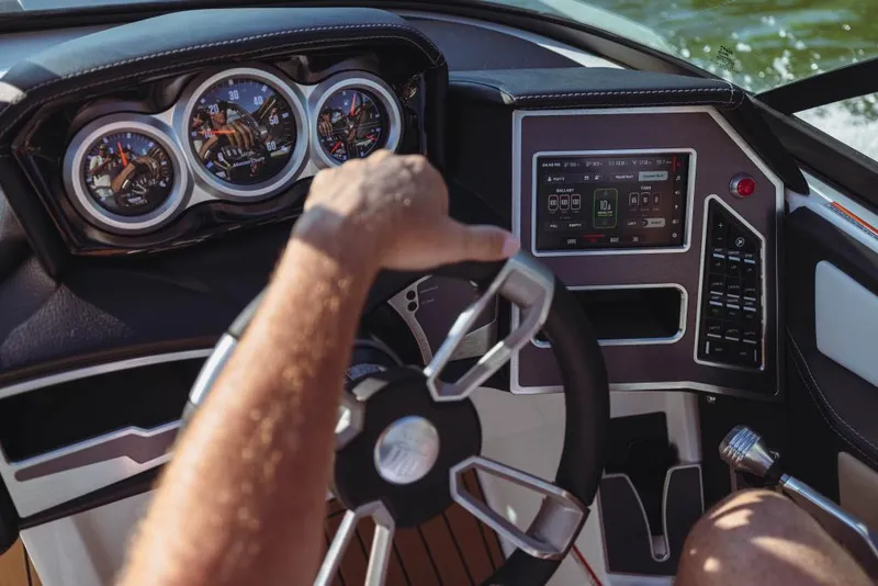Slide: The Image of 2023 MasterCraft XT20 boat dashboard with steering wheel and control panel. - 8