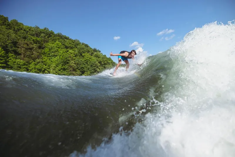 Slide: The Image of Person wakesurfing behind a 2023 MasterCraft XT20 boat on a sunny day. - 9