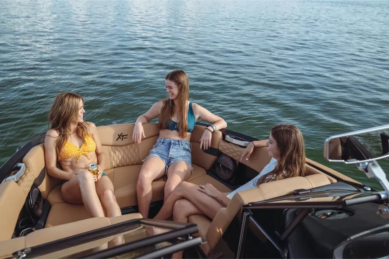 Slide: The Image of 2023 MasterCraft XT22 boat with three women relaxing on the water. - 10
