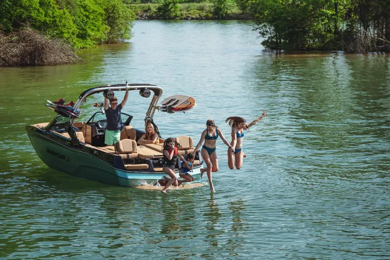 Slide: The Image of 2023 MasterCraft XT22 boat with people enjoying water activities. - 15