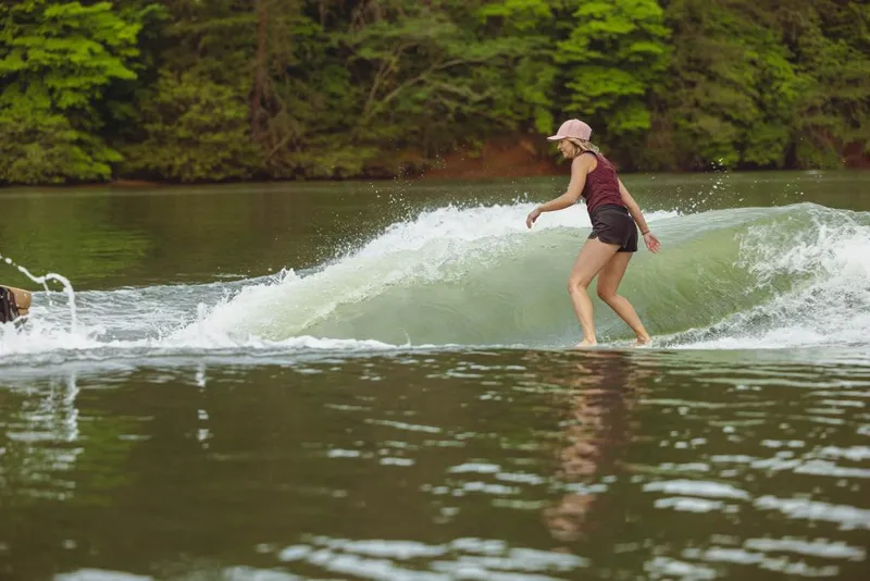 Slide: The Image of Person wakesurfing behind a 2023 MasterCraft XT22 boat on a lake. - 17