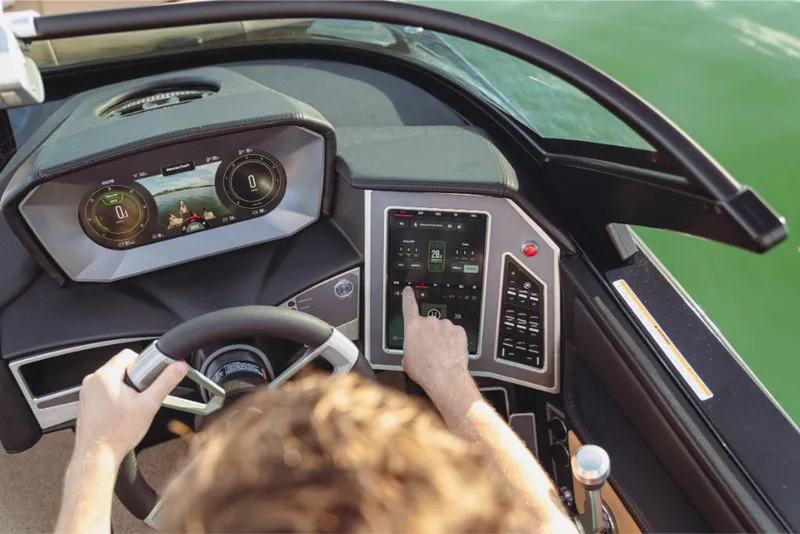 Slide: The Image of 2023 MasterCraft XT22 boat dashboard with advanced touchscreen controls and steering wheel. - 4