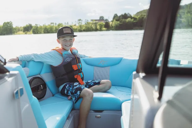 Slide: The Image of Young boy enjoying a ride on a 2023 MasterCraft XT23 boat. - 10