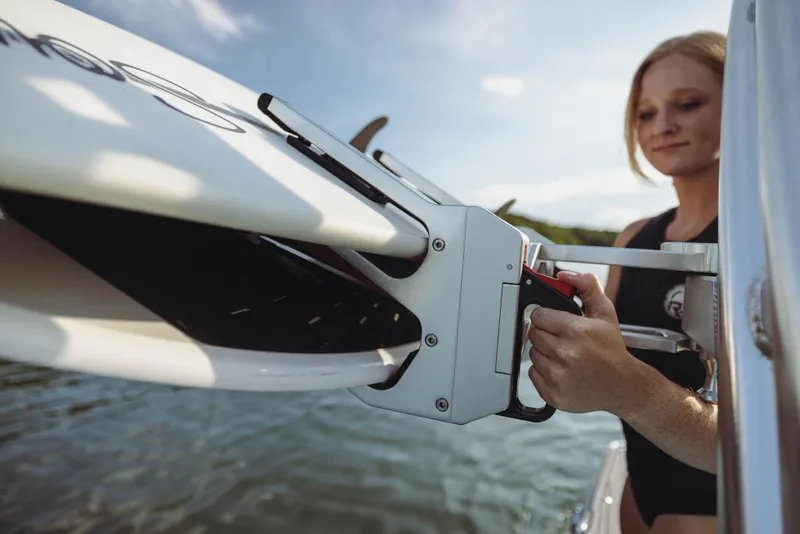 Slide: The Image of Woman securing wakeboard on 2023 MasterCraft XT23 boat. - 12