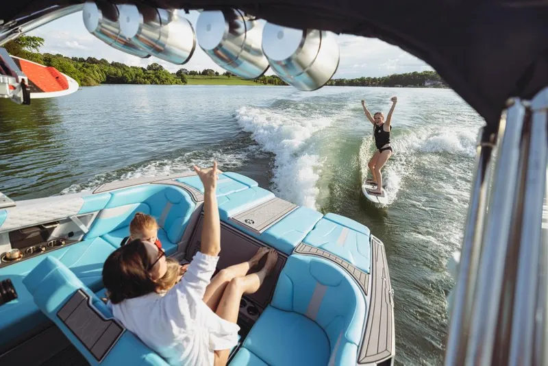 Slide: The Image of 2023 MasterCraft XT23 boat with people wakeboarding on a lake. - 15