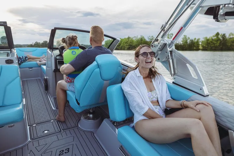 Slide: The Image of People enjoying a ride on a 2023 MasterCraft XT23 boat. - 16