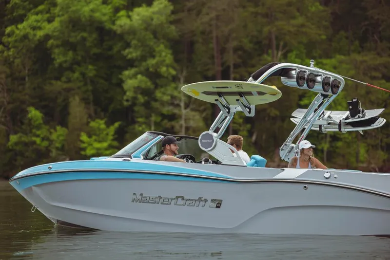Slide: The Image of 2023 MasterCraft XT23 boat on a lake with passengers and wakeboard equipment. - 5