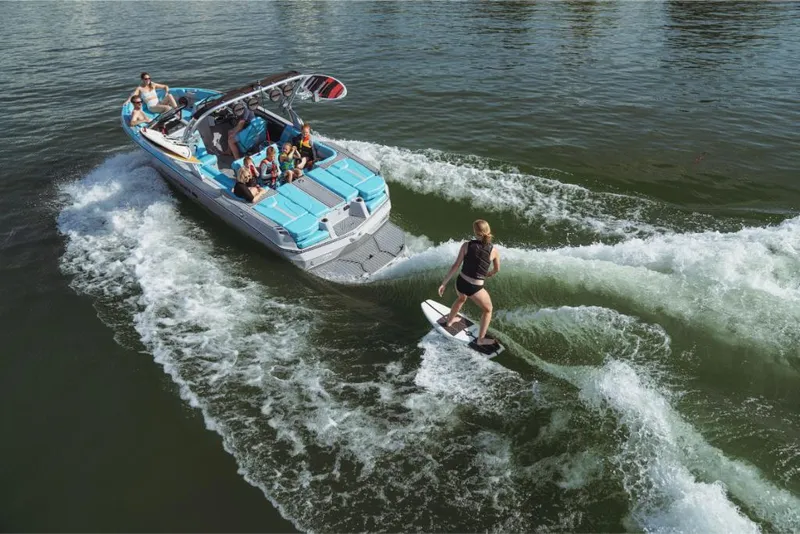 Slide: The Image of 2023 MasterCraft XT23 boat with people wakeboarding on a lake. - 6
