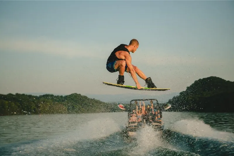Slide: The Image of Person wakeboarding behind a 2022 MasterCraft XT25 boat on a lake. - 12