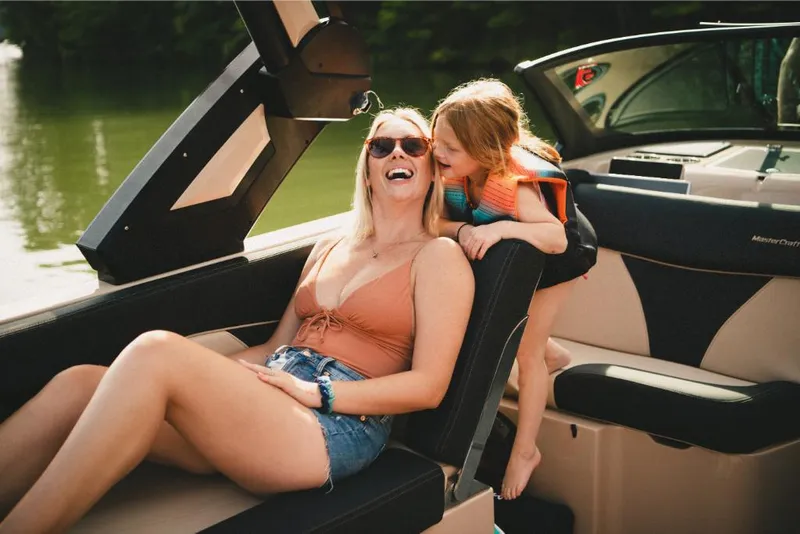 Slide: The Image of 2022 MasterCraft XT25 boat with happy family enjoying a sunny day on the water. - 6