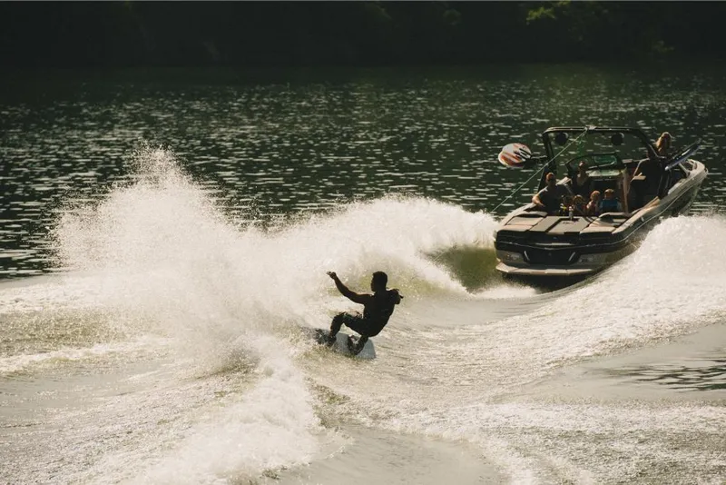 Slide: The Image of Person wakeboarding behind a 2022 MasterCraft XT25 boat on a lake. - 7