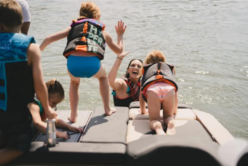 Slide: The Image of Family enjoying water activities on a 2022 MasterCraft XT25 boat. - 9