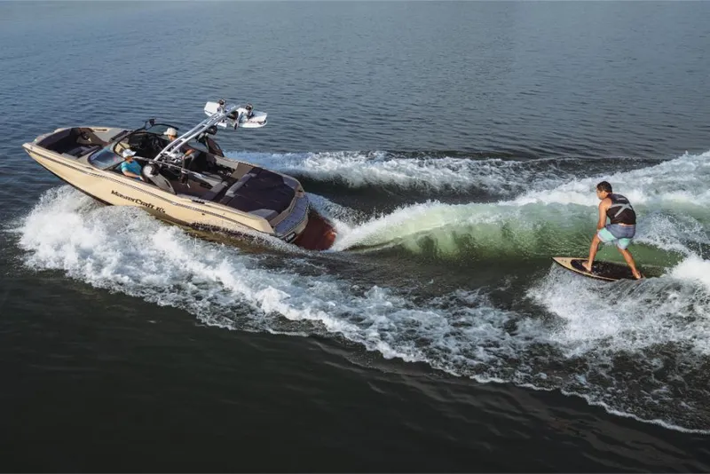 Slide: The Image of 2023 MasterCraft NXT20 boat towing a wakeboarder on a lake. - 0