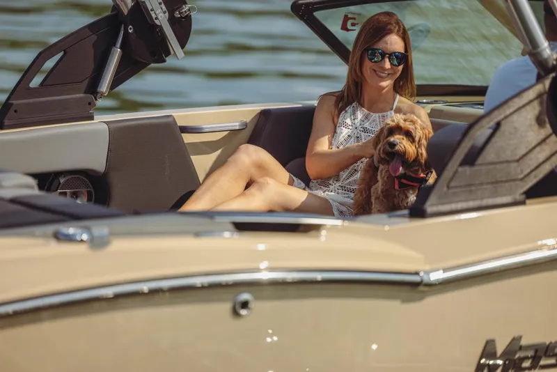 Slide: The Image of Woman with dog on 2023 MasterCraft NXT20 boat, enjoying a sunny day on the water. - 11