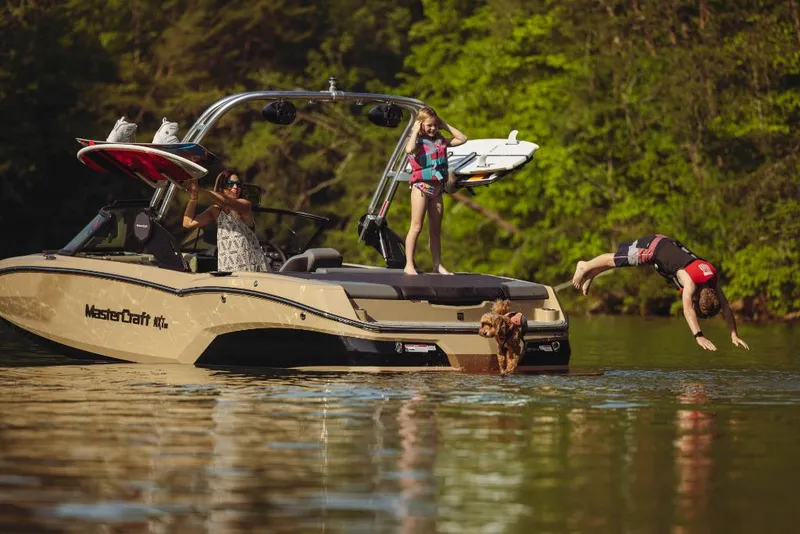 Slide: The Image of 2023 MasterCraft NXT20 boat with people enjoying water activities. - 14
