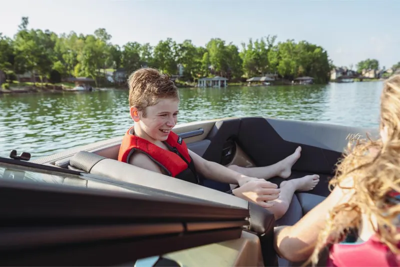 Slide: The Image of 2023 MasterCraft NXT20 boat with kids enjoying a sunny day on the lake. - 6