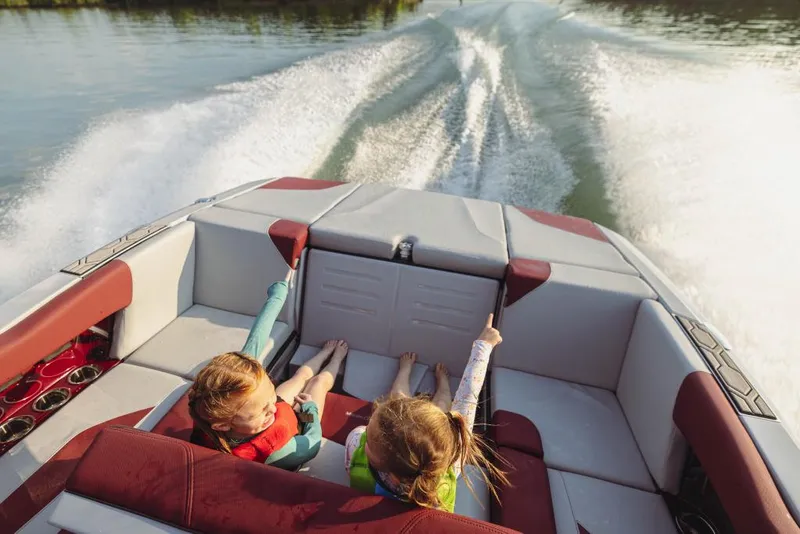 Slide: The Image of 2023 MasterCraft NXT22 boat with children enjoying a ride on the water. - 12
