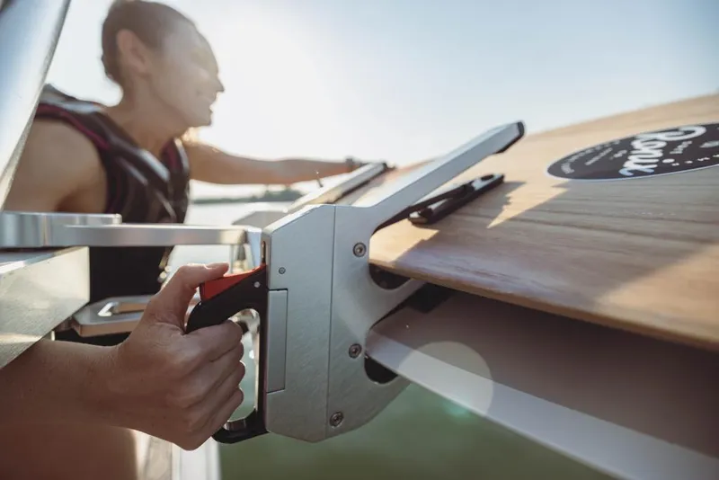 Slide: The Image of Person securing a wakeboard on a 2023 MasterCraft NXT22 boat. - 6