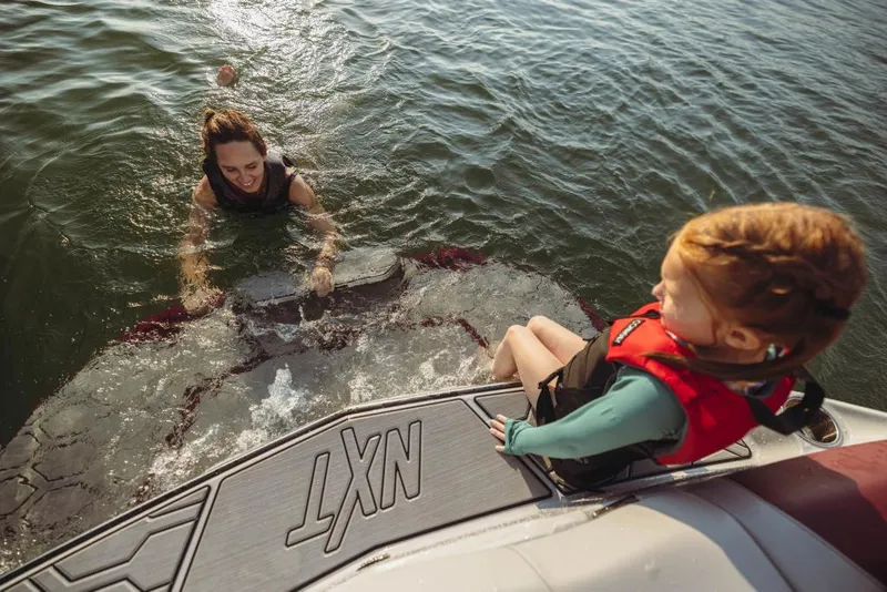 Slide: The Image of 2023 MasterCraft NXT22 boat with people enjoying water activities. - 9