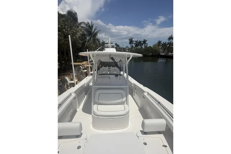 Slide: The Image of 2015 Southport 33 FE boat on a calm waterway, surrounded by palm trees. - 17