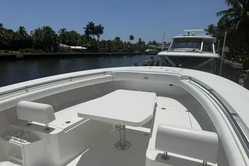 Slide: The Image of 2015 Southport 33 FE boat with spacious seating and table, docked by a scenic canal. - 19