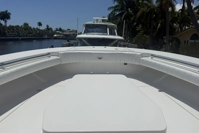 Slide: The Image of 2015 Southport 33 FE boat interior with white seating, docked near palm trees. - 20
