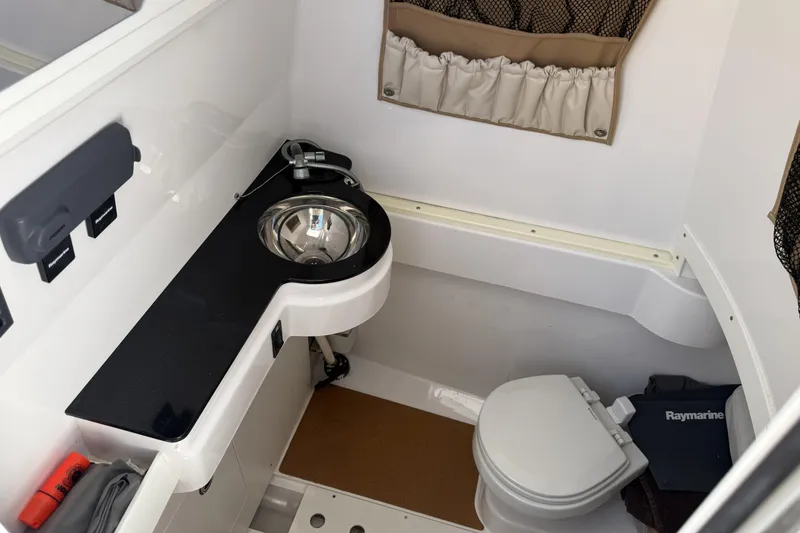 Slide: The Image of 2015 Southport 33 FE boat interior with sink and toilet in compact bathroom. - 23