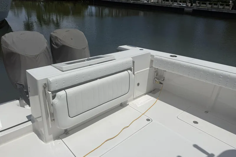 Slide: The Image of 2015 Southport 33 FE boat with covered engines and white seating by the water. - 6